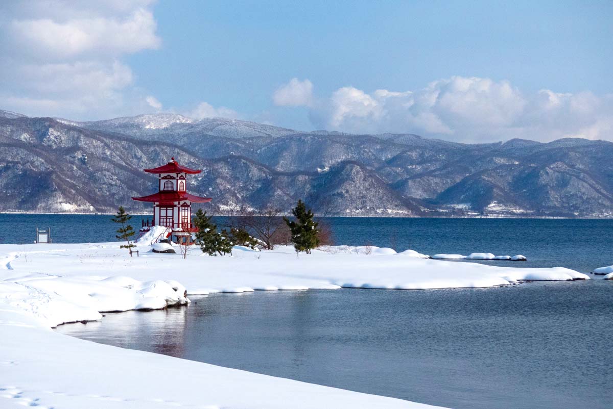Lake Toya with island and Japanese building, fresh snow in mid-winter