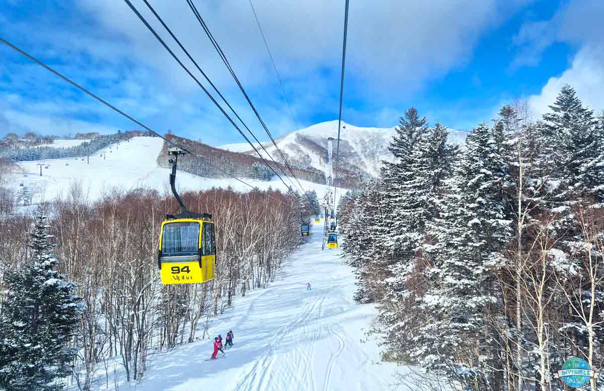 UNKAI Gondola cabins rising through snowy trees at Hoshino Resorts Tomamu