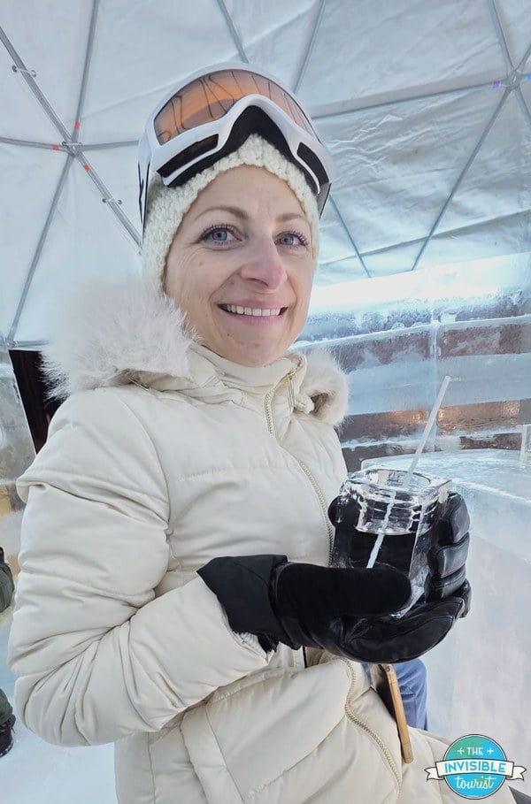 Alyse holding a drink in an ice glass at the Ice Bar in the Ice Village, Hoshino Resorts Tomamu