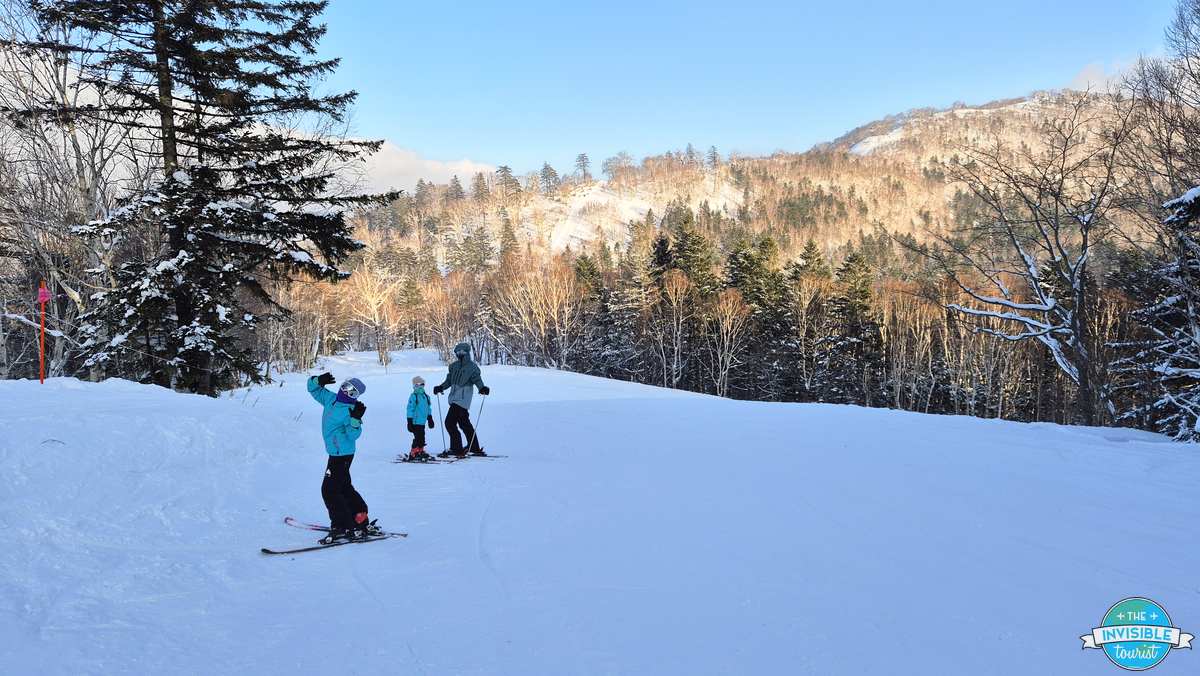 Children skiing down a gentle beginner slope at Tomamu ski resort